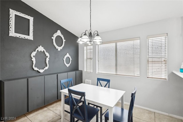 tiled dining space featuring lofted ceiling and an inviting chandelier