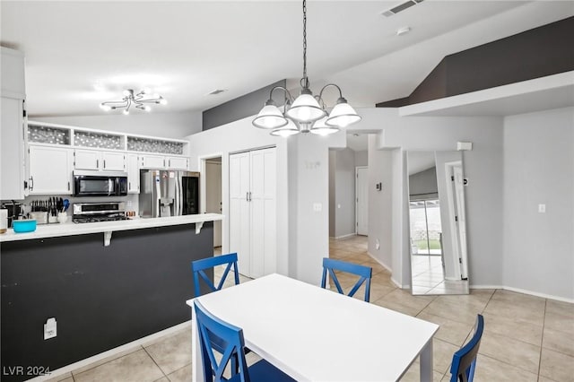 tiled dining area featuring lofted ceiling and an inviting chandelier