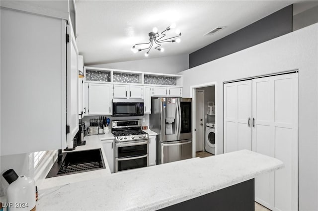 kitchen featuring kitchen peninsula, appliances with stainless steel finishes, white cabinetry, and lofted ceiling