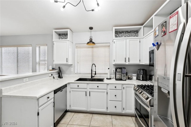 kitchen featuring sink, stainless steel appliances, light tile patterned floors, decorative light fixtures, and white cabinets