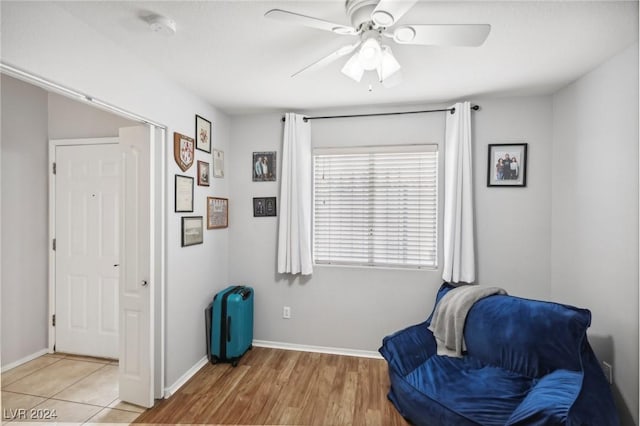 sitting room with ceiling fan and light wood-type flooring