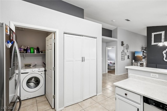 laundry room with washer / clothes dryer and light tile patterned floors