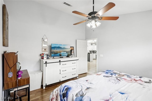 bedroom featuring a high ceiling, hardwood / wood-style flooring, and ceiling fan