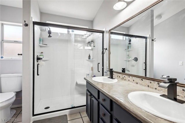 bathroom with tile patterned floors, vanity, toilet, and walk in shower