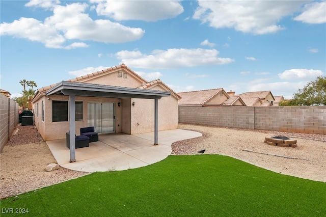 rear view of property featuring a patio area and an outdoor fire pit