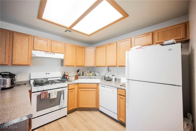 kitchen featuring light wood-type flooring, light brown cabinets, white appliances, and sink