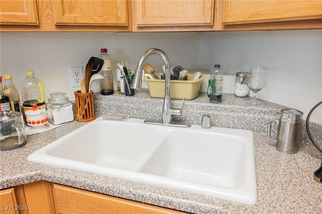 details featuring light stone countertops and sink