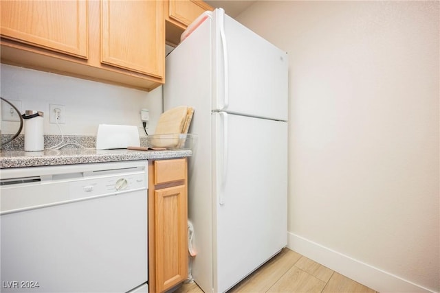 kitchen featuring light brown cabinetry and white appliances