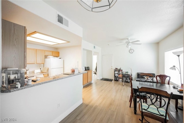 kitchen featuring ceiling fan, light brown cabinetry, white fridge, and light hardwood / wood-style floors