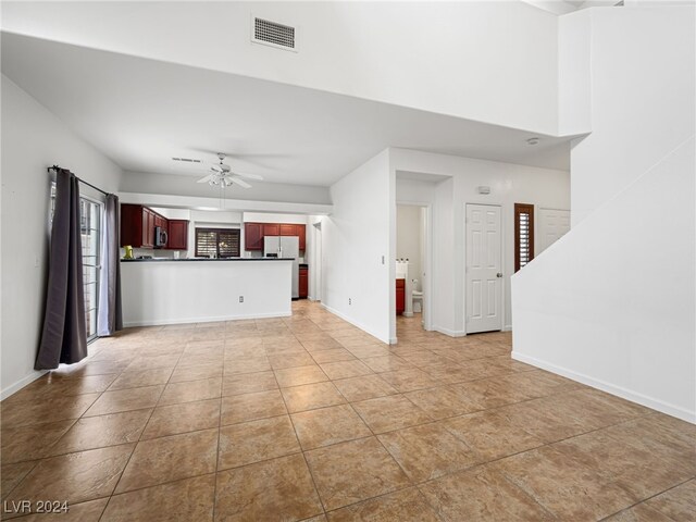 unfurnished living room with ceiling fan and light tile patterned floors