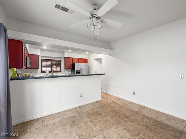 kitchen with kitchen peninsula, appliances with stainless steel finishes, light tile patterned floors, and ceiling fan