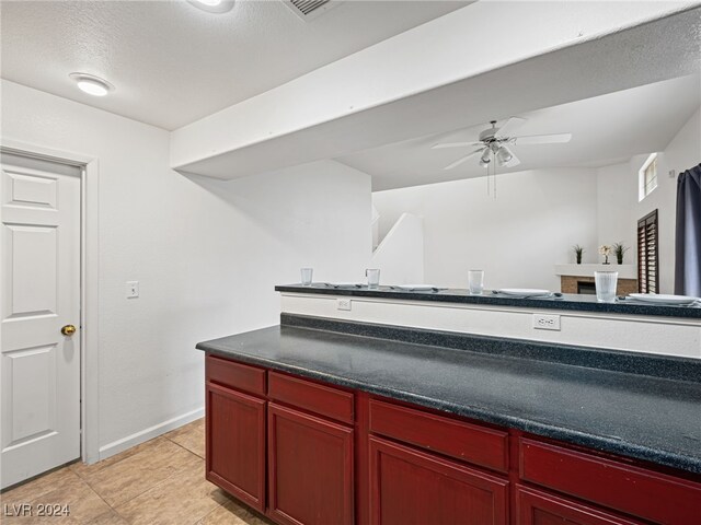 kitchen with ceiling fan, light tile patterned flooring, and a textured ceiling