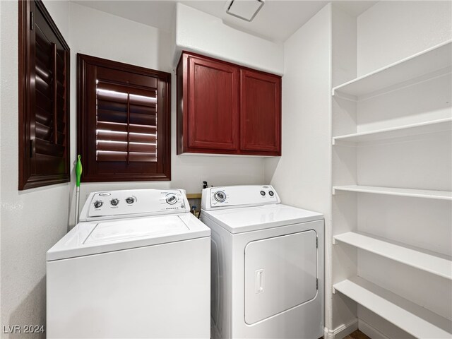 clothes washing area featuring cabinets and washer and dryer