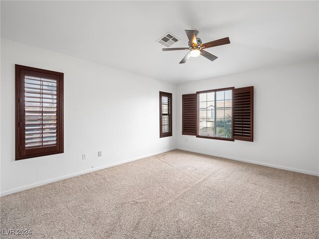 empty room with ceiling fan and light carpet