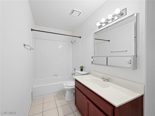 full bathroom featuring tiled shower / bath, tile patterned flooring, vanity, and toilet