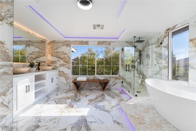 bathroom with a wealth of natural light, vanity, and shower with separate bathtub