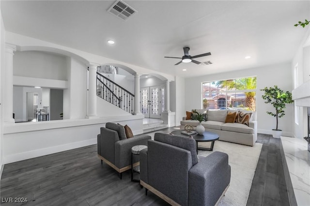 living room with dark hardwood / wood-style floors, ornate columns, and ceiling fan