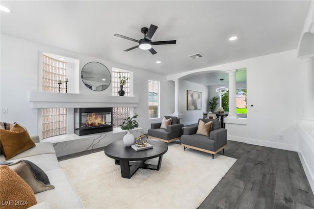 living room with ornate columns, ceiling fan, and dark hardwood / wood-style floors