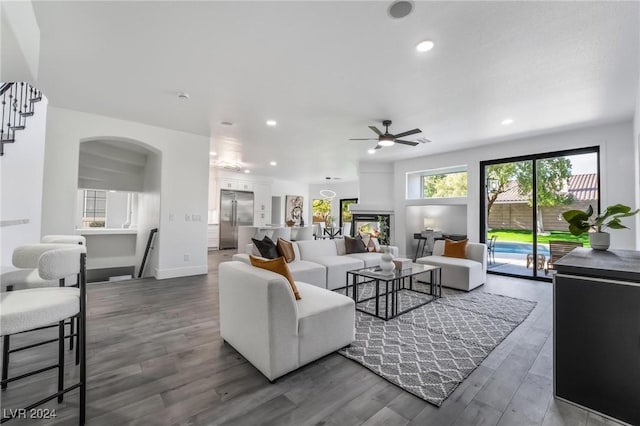 living room with ceiling fan and dark wood-type flooring