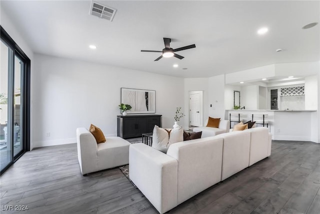 living room with ceiling fan and dark hardwood / wood-style flooring