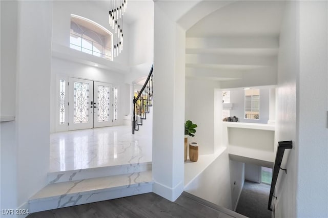 foyer with french doors, a towering ceiling, and dark hardwood / wood-style floors