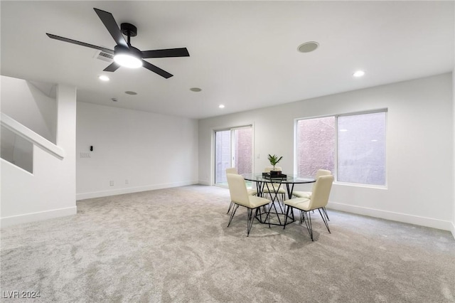 dining room with ceiling fan and light carpet