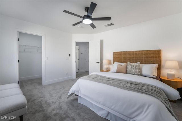 bedroom with carpet, a closet, a spacious closet, and ceiling fan