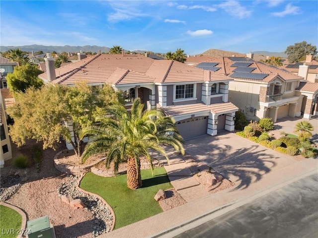 view of front of home with solar panels, a front yard, and a garage