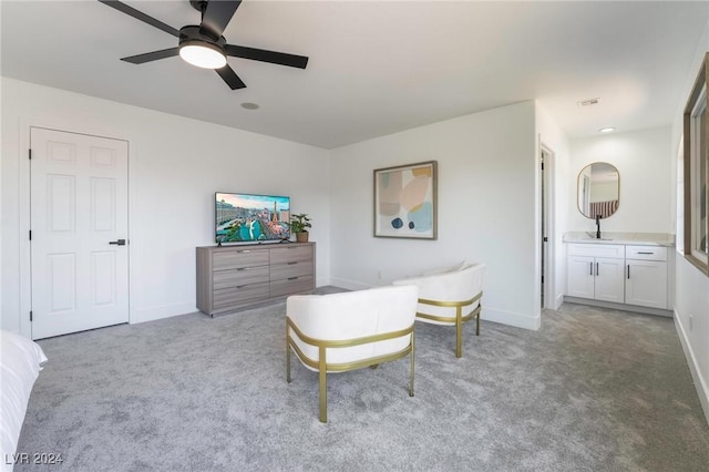 sitting room with ceiling fan and light colored carpet