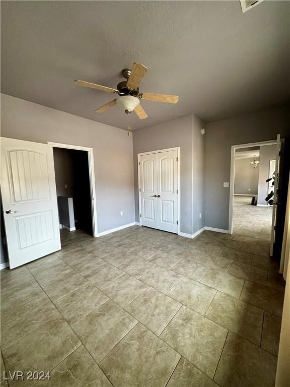 unfurnished bedroom with ceiling fan and a closet