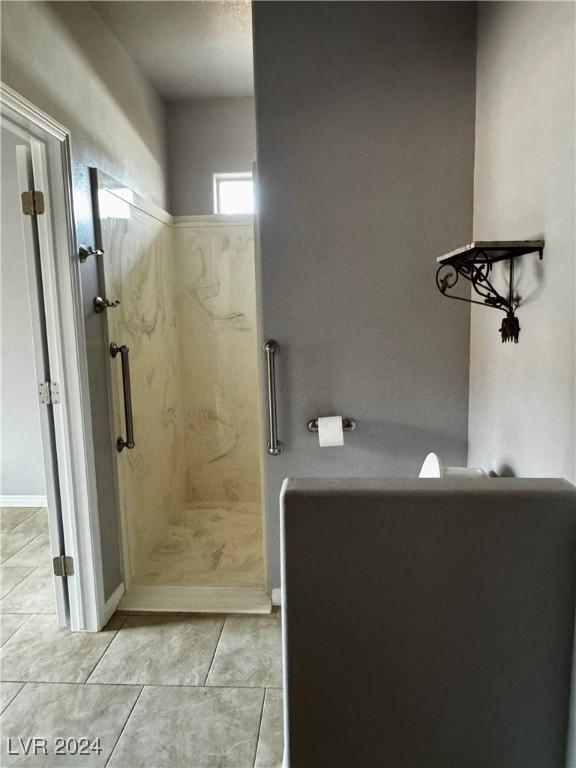 bathroom with tile patterned floors and tiled shower