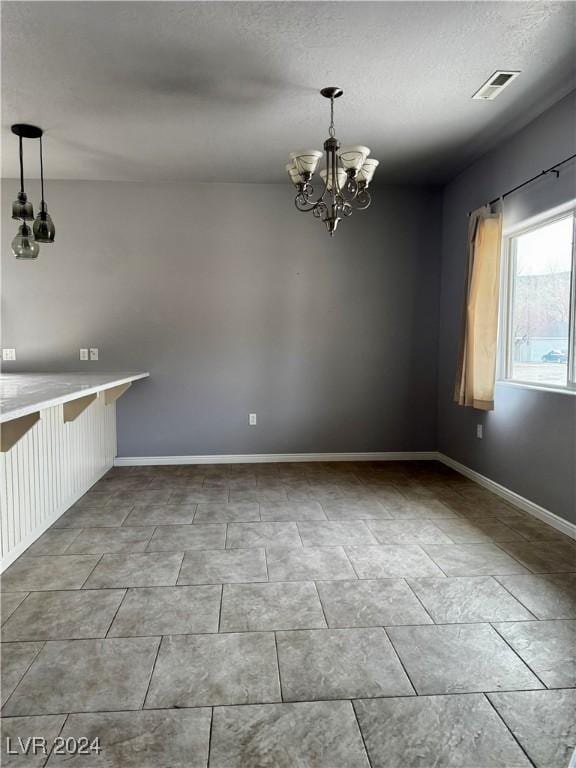 unfurnished dining area with a chandelier