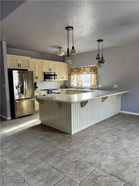 kitchen with a kitchen bar, decorative backsplash, stainless steel appliances, light tile patterned floors, and hanging light fixtures