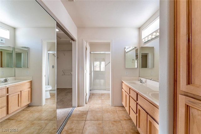 bathroom featuring tile patterned floors, vanity, toilet, and an enclosed shower