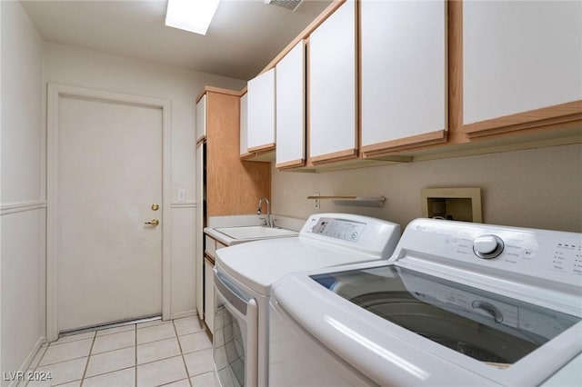 laundry area featuring cabinets, light tile patterned floors, washer and clothes dryer, and sink