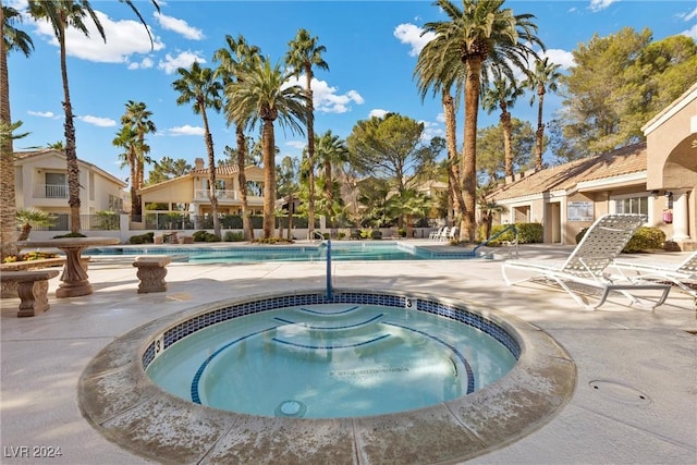 view of pool featuring a hot tub and a patio