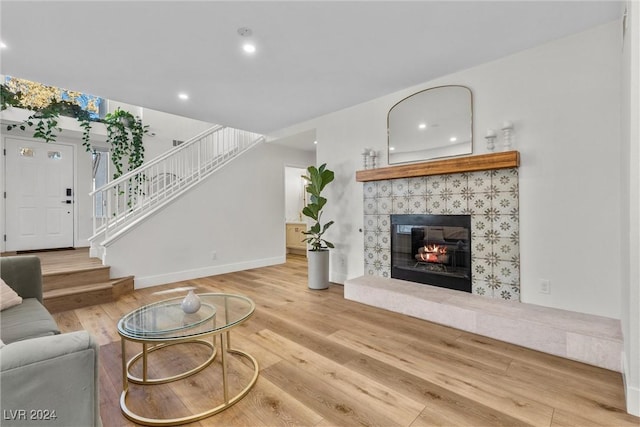 living room with hardwood / wood-style flooring and a tiled fireplace