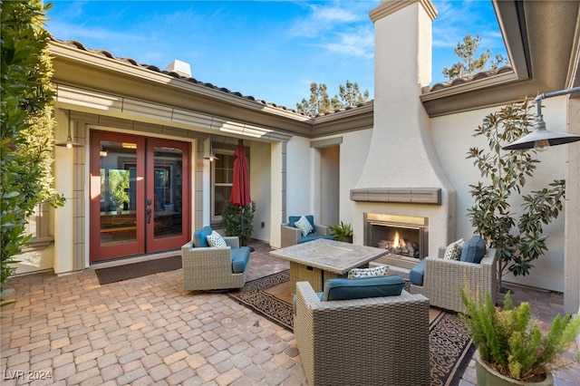 view of patio with french doors and exterior fireplace