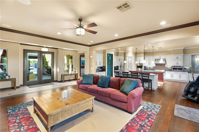 living room with hardwood / wood-style flooring, ceiling fan, and ornamental molding