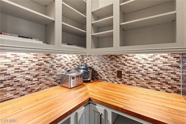 kitchen with gray cabinetry, wood counters, and tasteful backsplash