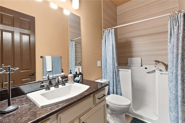 bathroom featuring toilet, vanity, and walk in shower