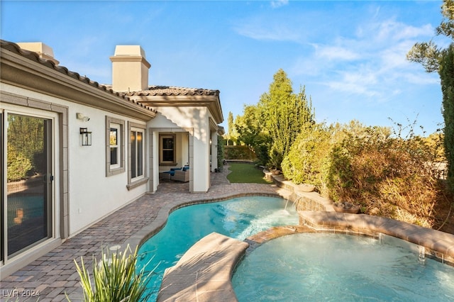 view of swimming pool featuring a patio area and an in ground hot tub