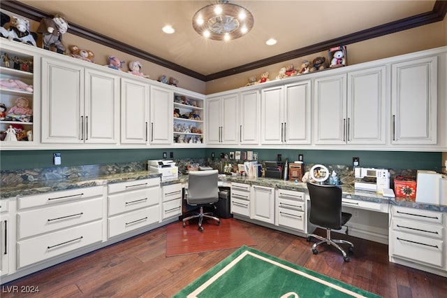 home office featuring built in desk, crown molding, and dark wood-type flooring