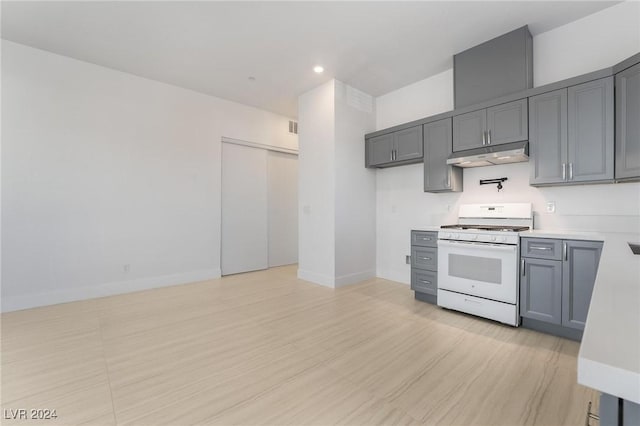 kitchen featuring gray cabinetry, gas range gas stove, and light hardwood / wood-style floors