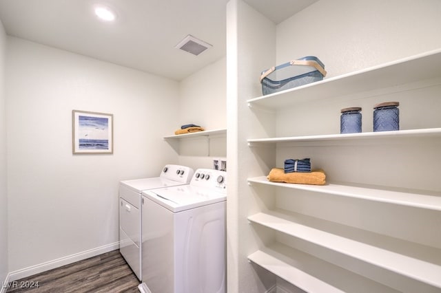 laundry area with dark hardwood / wood-style flooring and washing machine and dryer