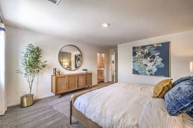 bedroom featuring ensuite bathroom and light colored carpet