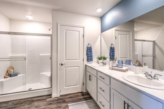 bathroom with hardwood / wood-style floors, vanity, and a shower with shower door