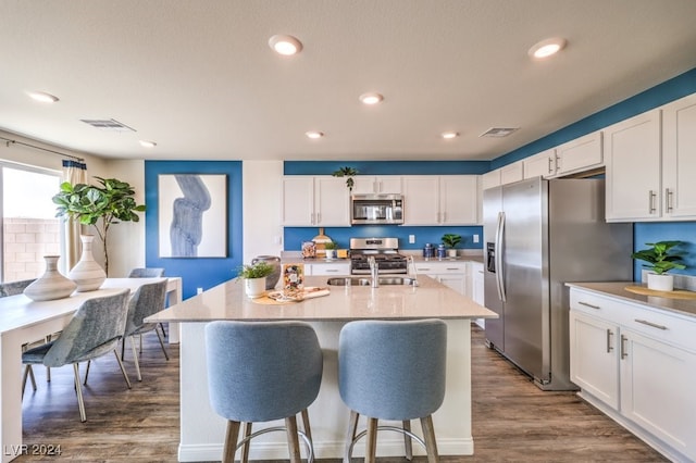 kitchen with white cabinets, dark wood-type flooring, and appliances with stainless steel finishes