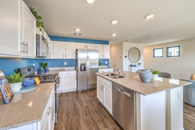 kitchen featuring white cabinetry, stainless steel appliances, and a kitchen island with sink