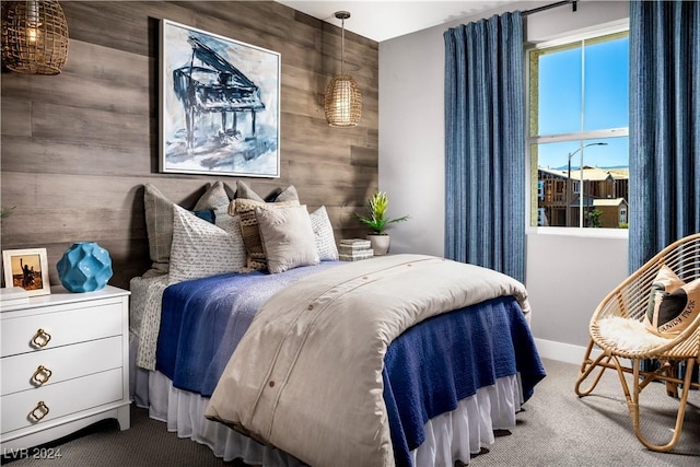 bedroom featuring carpet floors and wooden walls